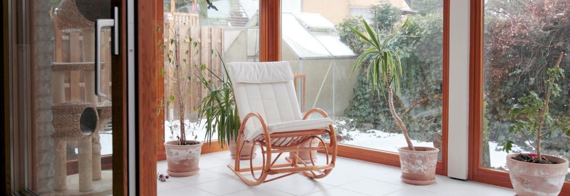 moderner Wintergarten mit Glasschiebetür und Schaukelstuhl